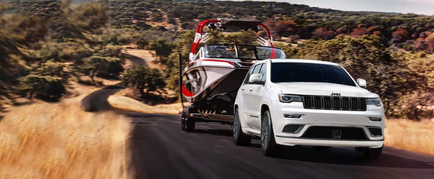 The 2021 Jeep Grand Cherokee towing a boat.