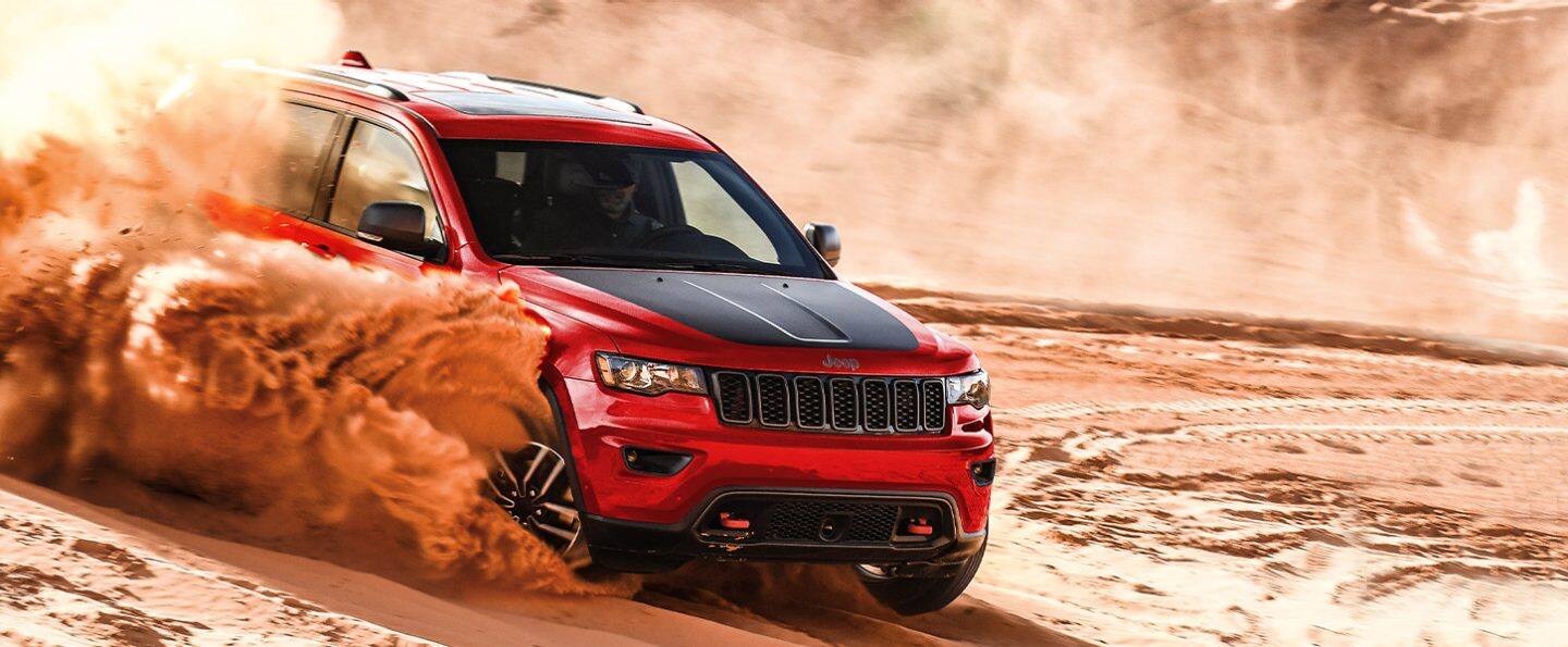 The 2021 Jeep Grand Cherokee Trailhawk being driven through deep sand.