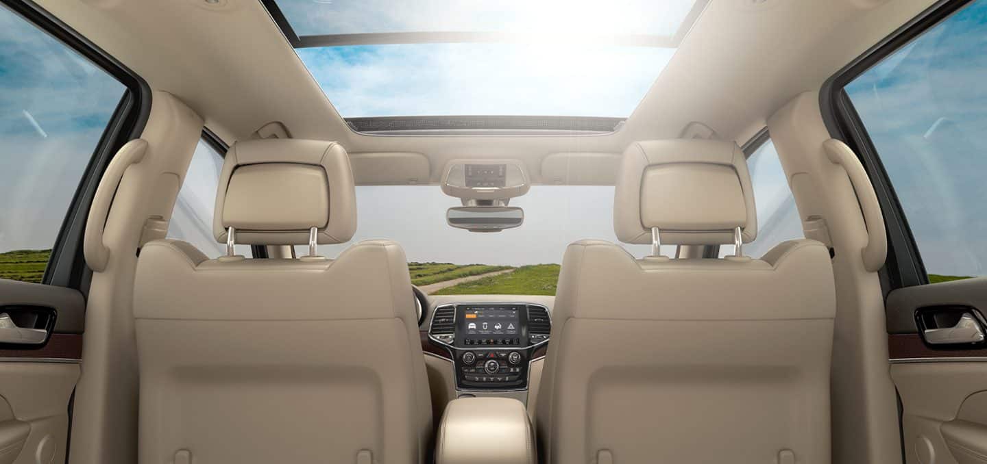Display The interior of the 2021 Jeep Grand Cherokee with the sunroof open.