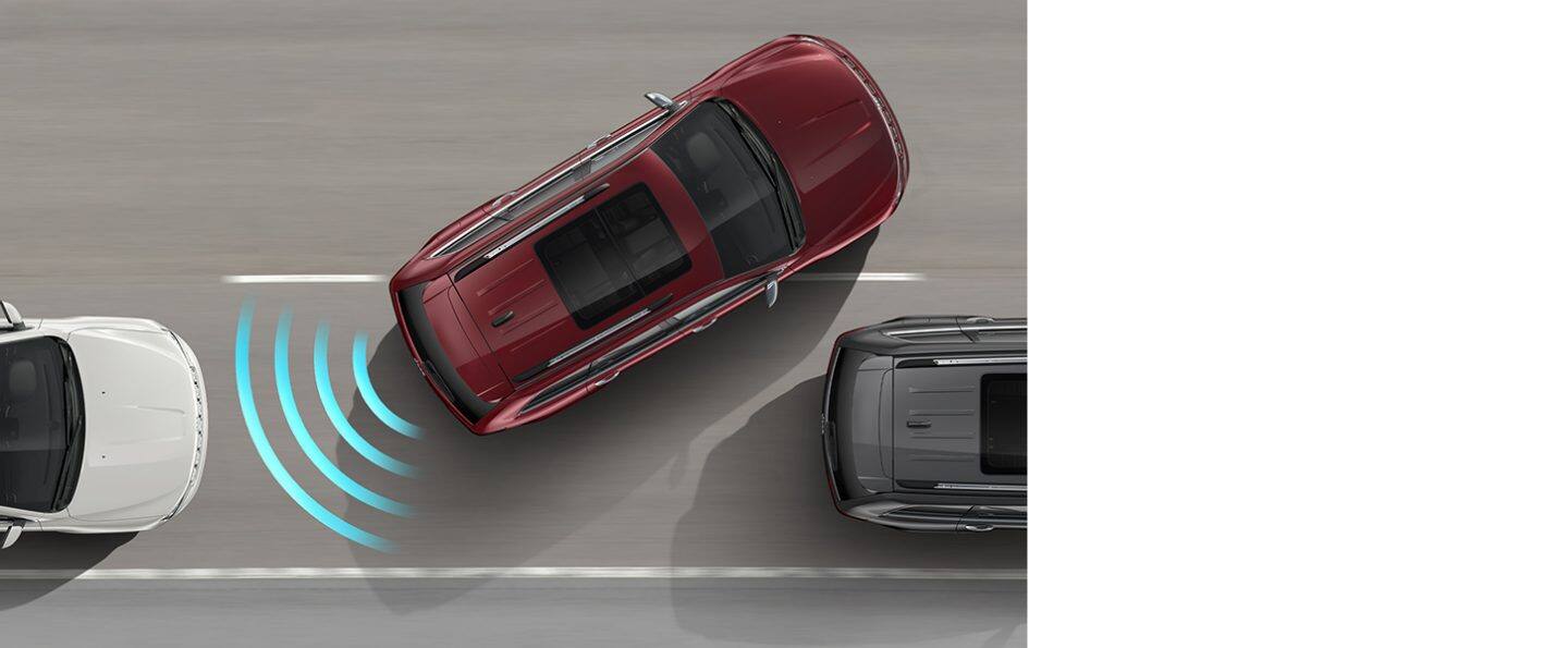 The 2021 Jeep Grand Cherokee illustrated with sensors monitoring the area in the rear as it parallel parks between two other vehicles.