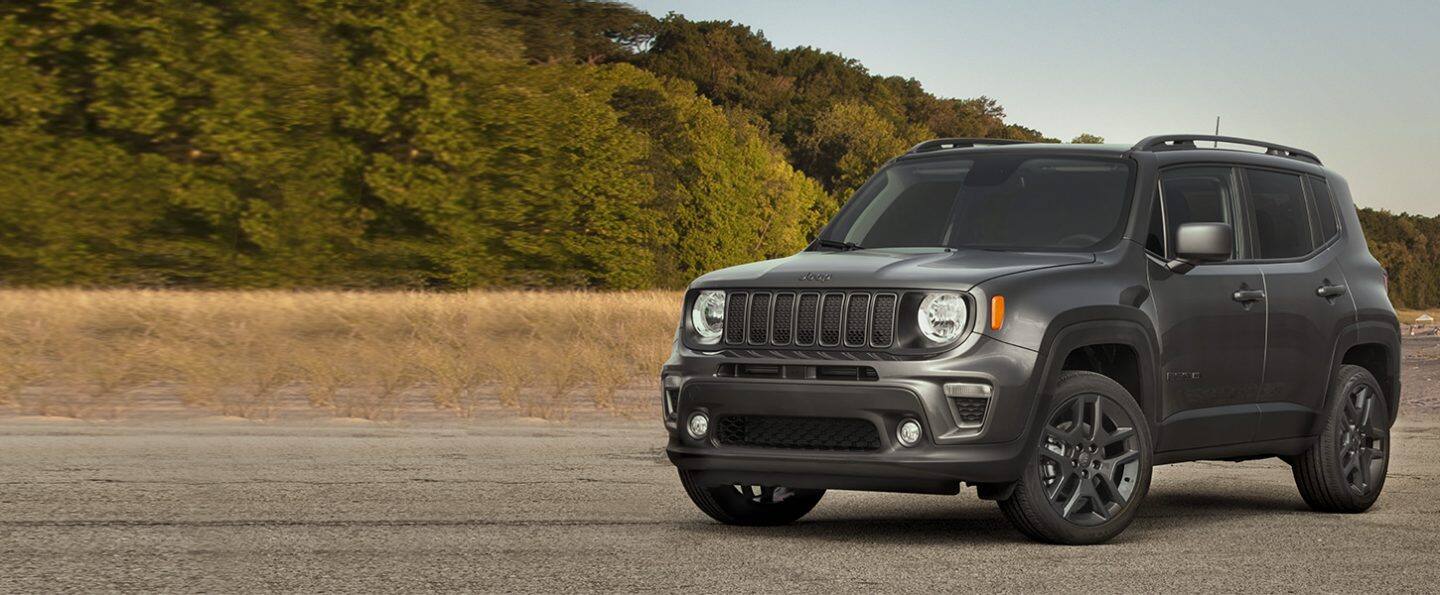 A gray 2021 Jeep Renegade 80th Anniversary Edition parked near the woods.
