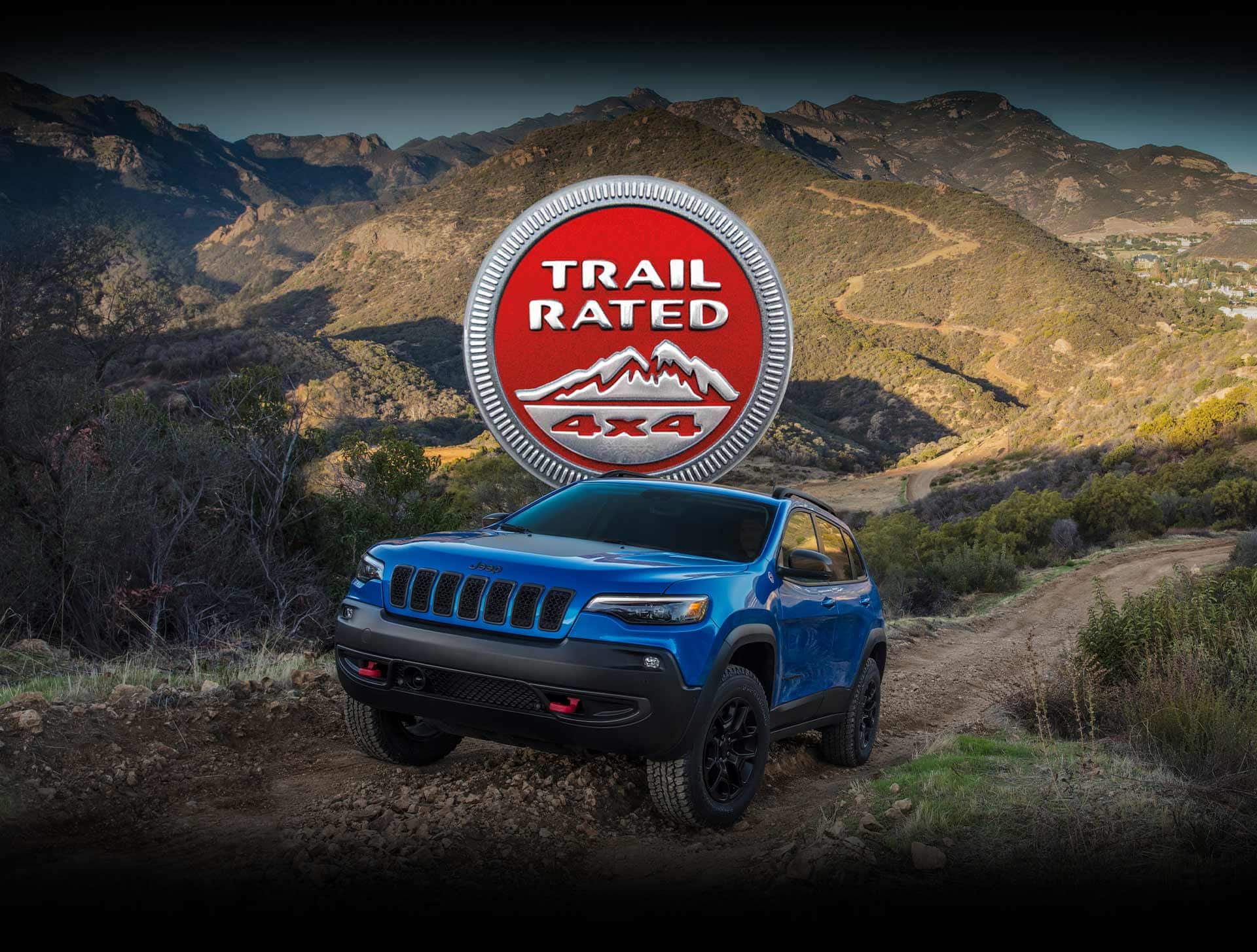 Trail Rated 4x4. The 2022 Jeep Cherokee Trailhawk being driven off-road on a dirt trail in the mountains.