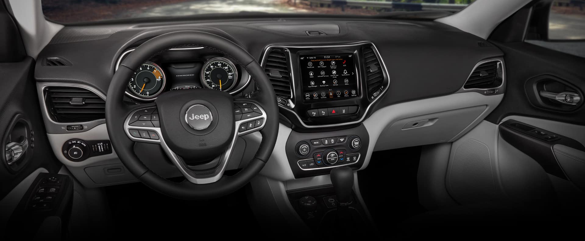 The steering wheel, dashboard and entertainment system in the cabin of the 2022 Jeep Cherokee Limited.