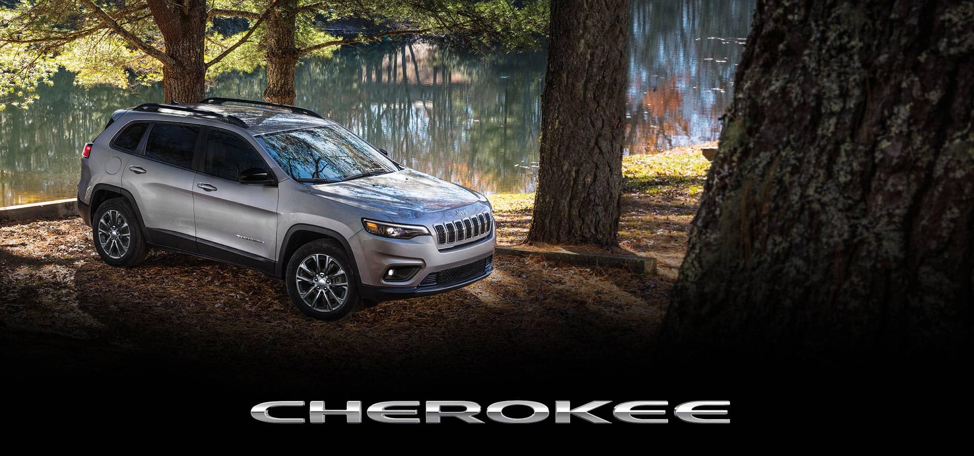 Cherokee. Un Jeep Cherokee Latitude Lux 2022 estacionado en una ciénaga al lado de un pantano, rodeado de grandes árboles.