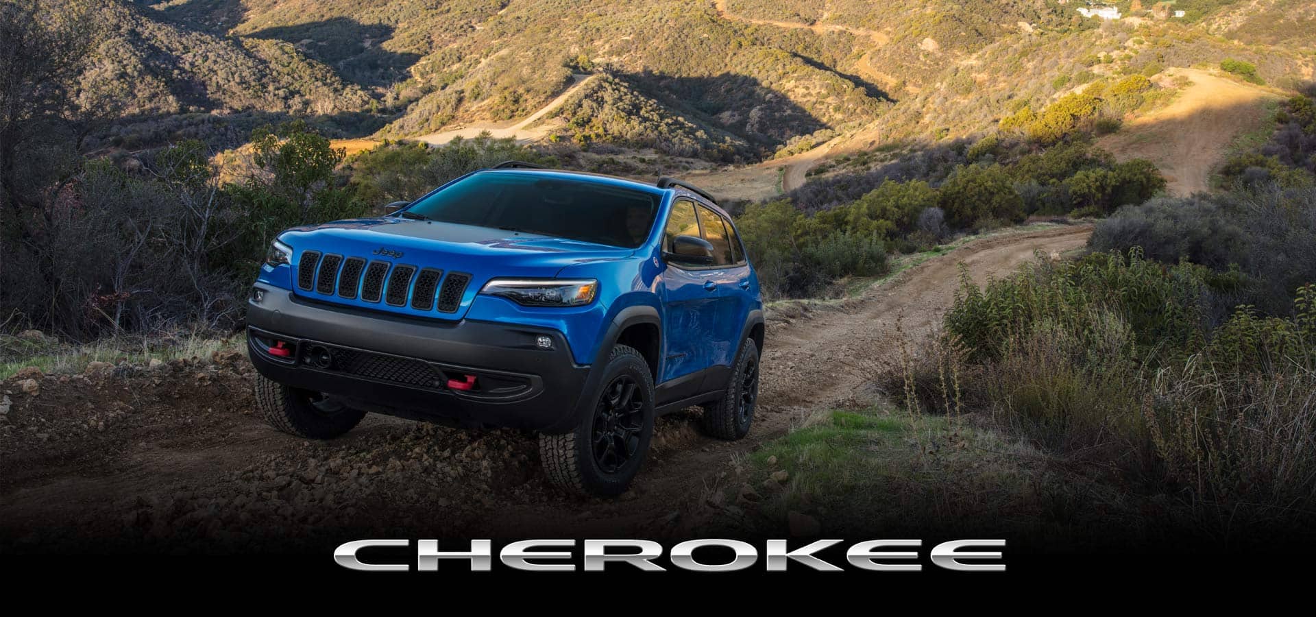 A blue 2022 Jeep Cherokee Trailhawk climbing a hill off-road. Cherokee.