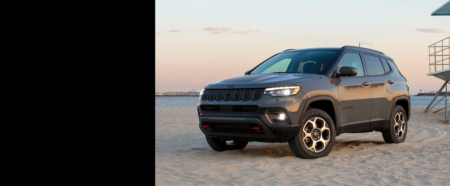 The 2022 Jeep Compass Trailhawk parked on a sandy beach.