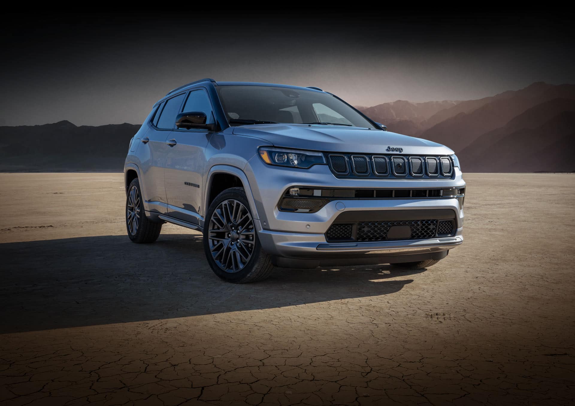 The 2022 Jeep Compass High Altitude parked in the desert with mountains rising in the distance.