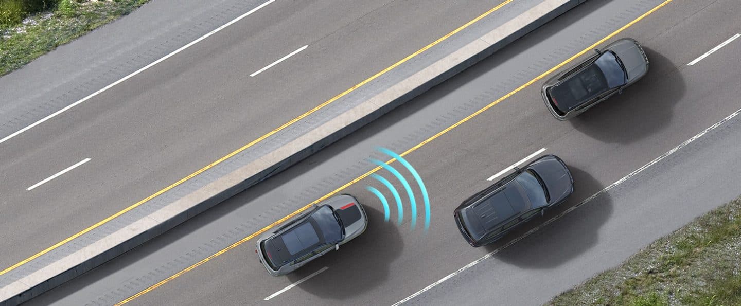 The 2022 Jeep Compass Trailhawk with illustrated sensor bars emanating from its front as it shares the road with other vehicles.