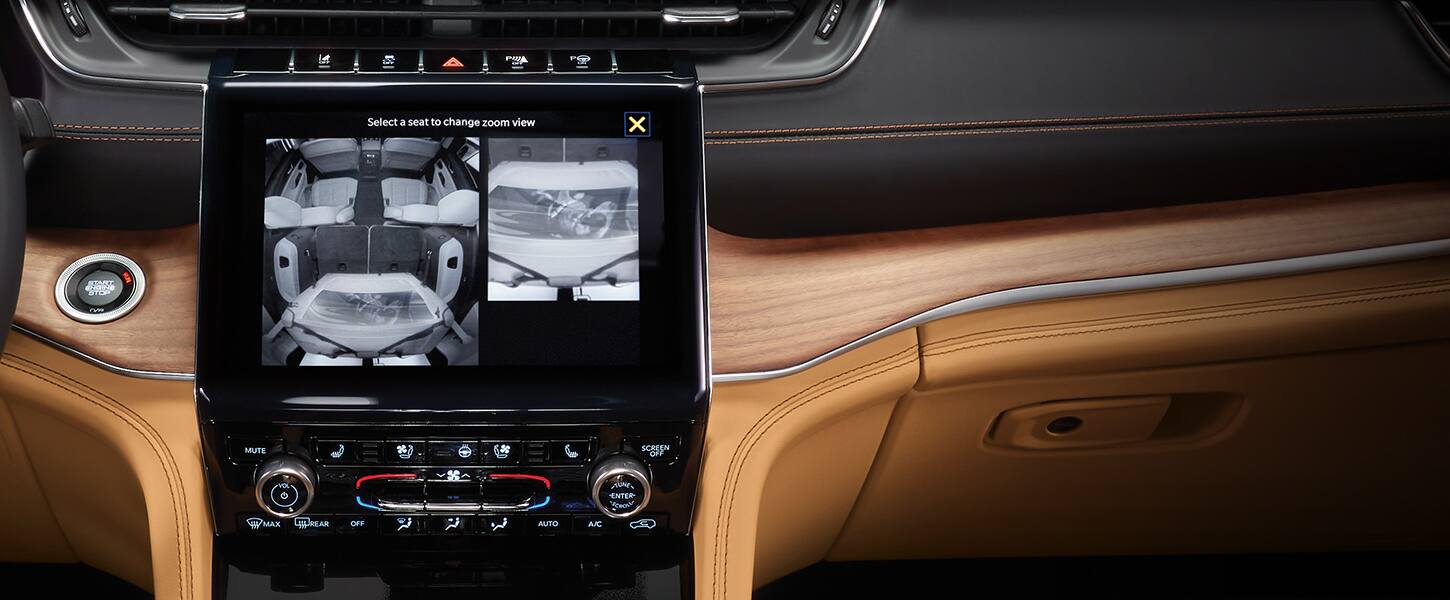 The Uconnect touchscreen inside the 2022 Jeep Grand Cherokee displaying three different angles from the rear seat camera.