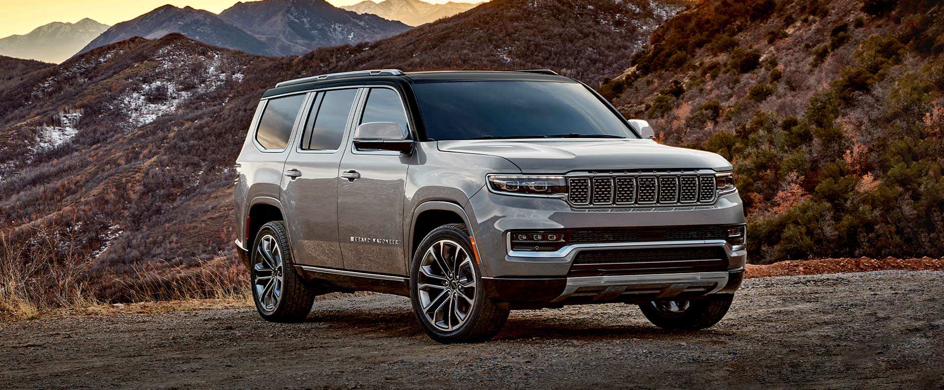 The 2022 Grand Wagoneer Series III parked on a gravel road with mountains rising behind it.