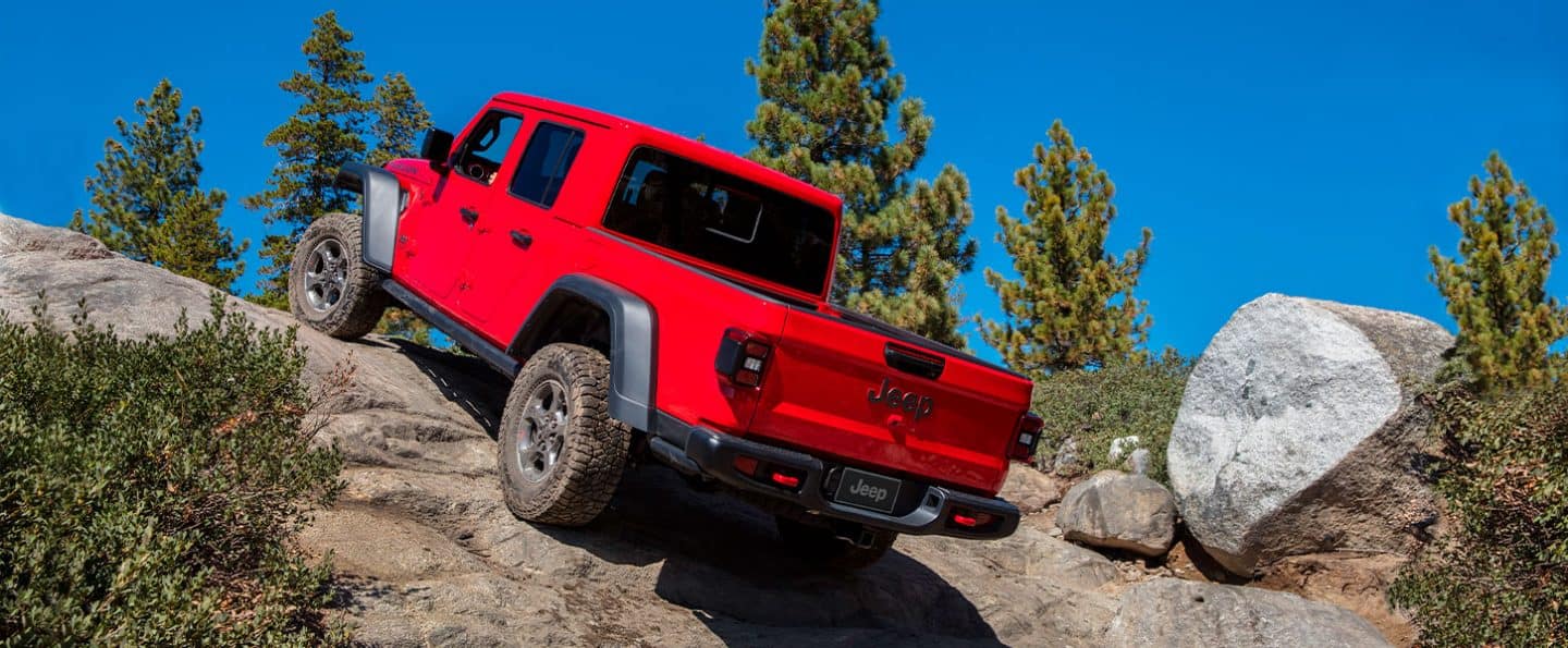 The 2022 Jeep Gladiator ascending a steep rock face.