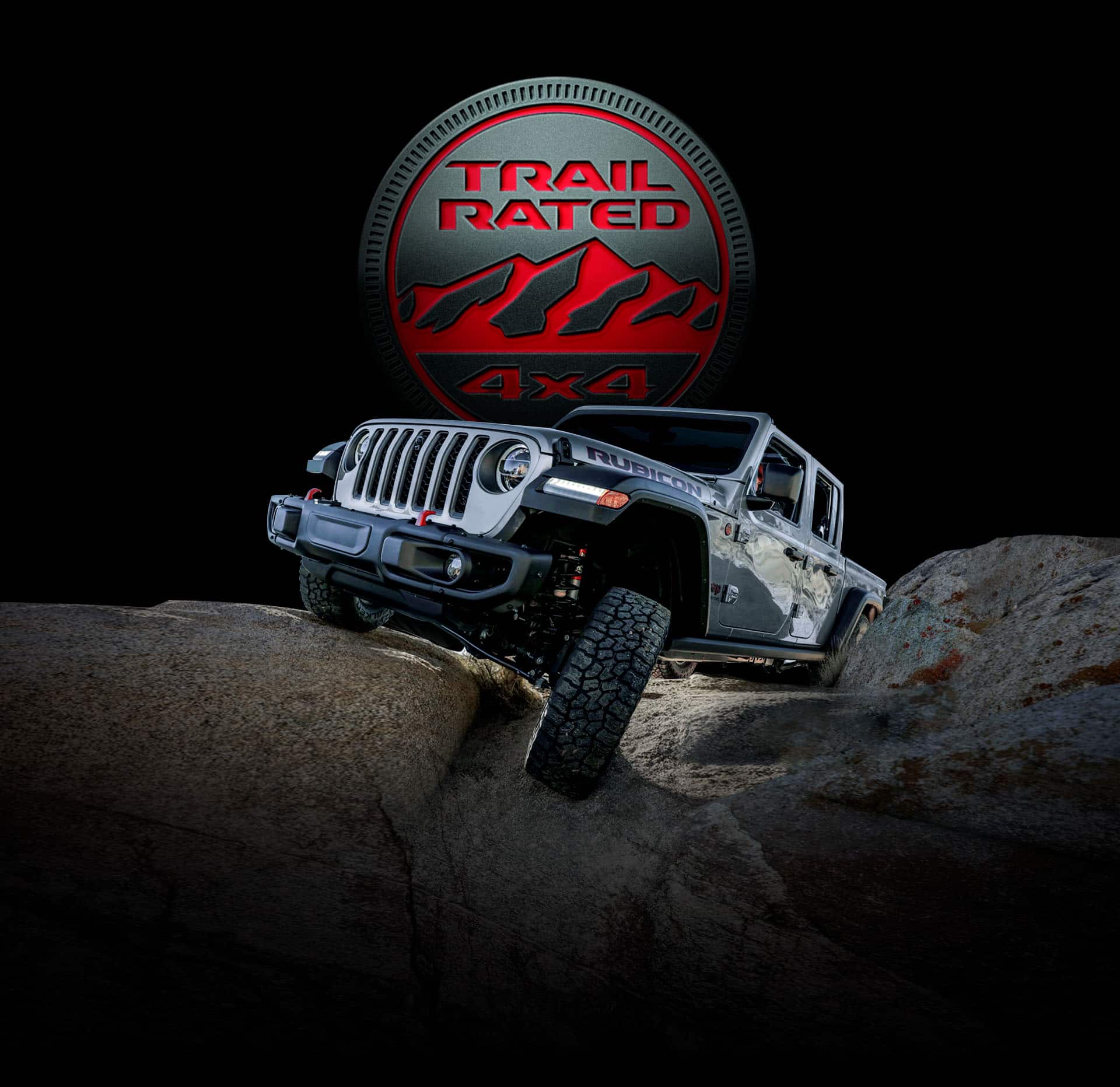 Trail Rated 4x4. La Jeep Gladiator Rubicon 2022 transitando sobre un terreno rocoso con una rueda elevada mientras sube una roca.
