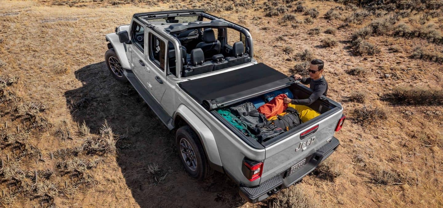 Display A top-down view of the 2022 Jeep Gladiator Overland with its tonneau cover partially rolled up and its bed packed with camping gear.