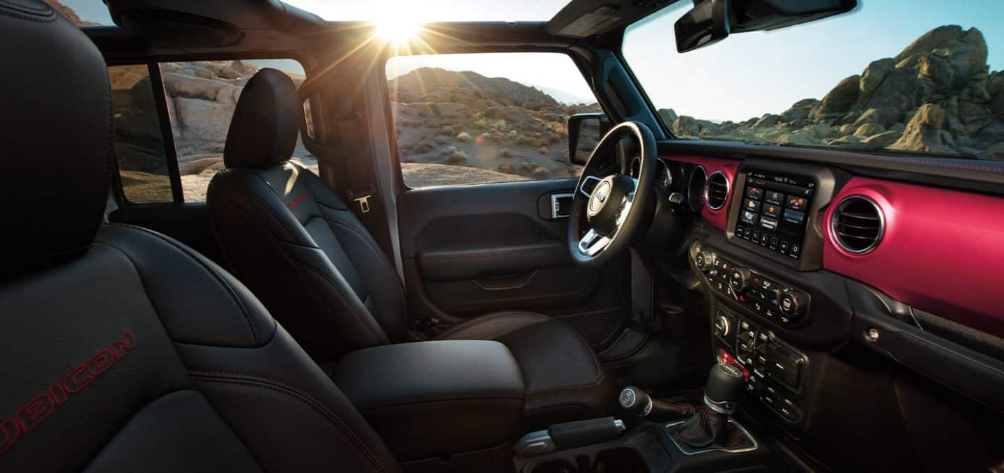 Display The interior of the 2022 Jeep Gladiator Rubicon with its top off and magenta accents around the vents. 