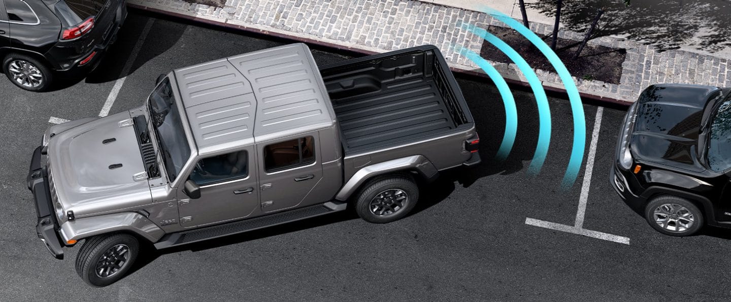 Illustrated sensor bars coming from the rear of the 2022 Jeep Gladiator Overland as it parallel parks between two vehicles.