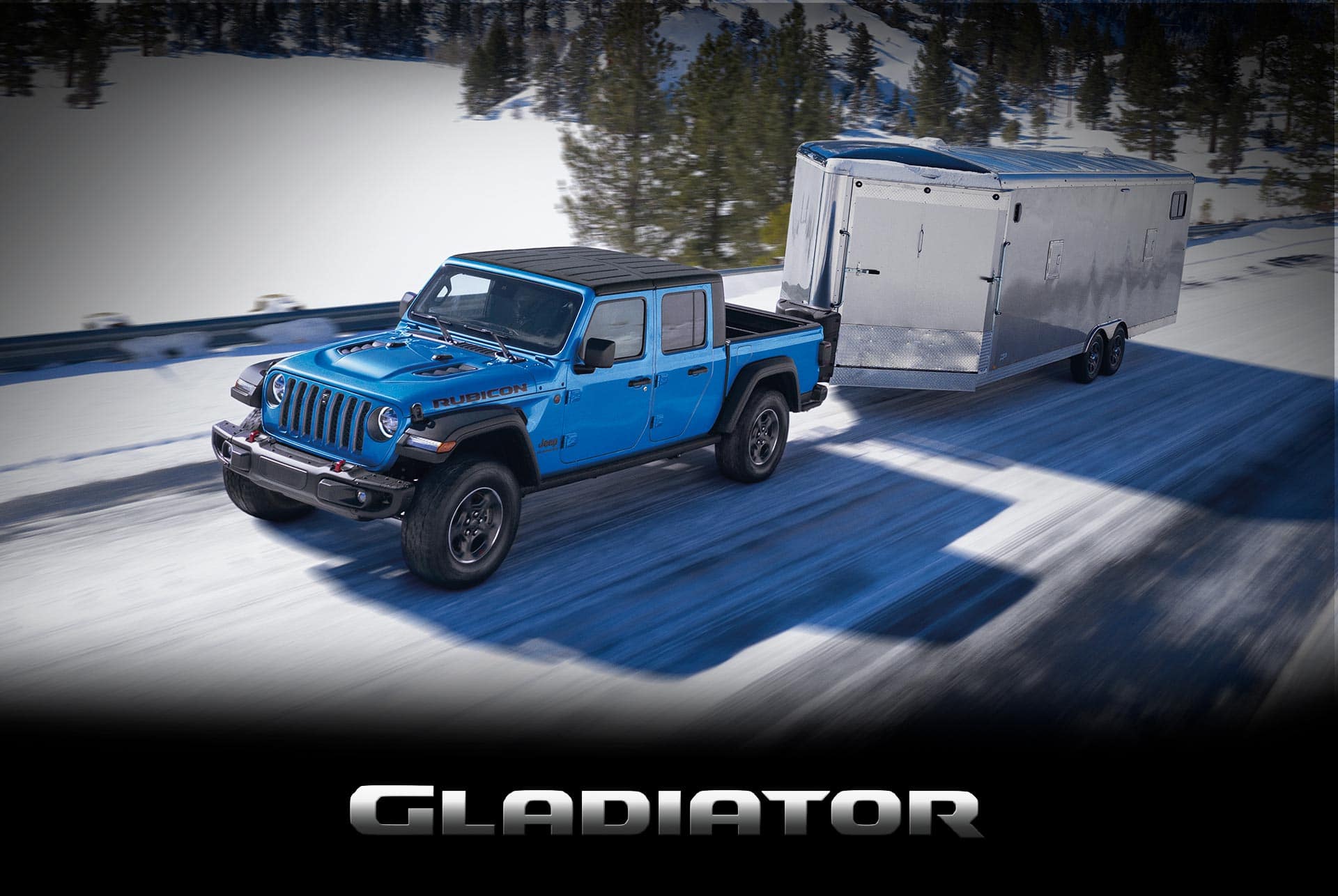 The 2022 Jeep Gladiator Rubicon towing an enclosed trailer on a snowy mountain road.