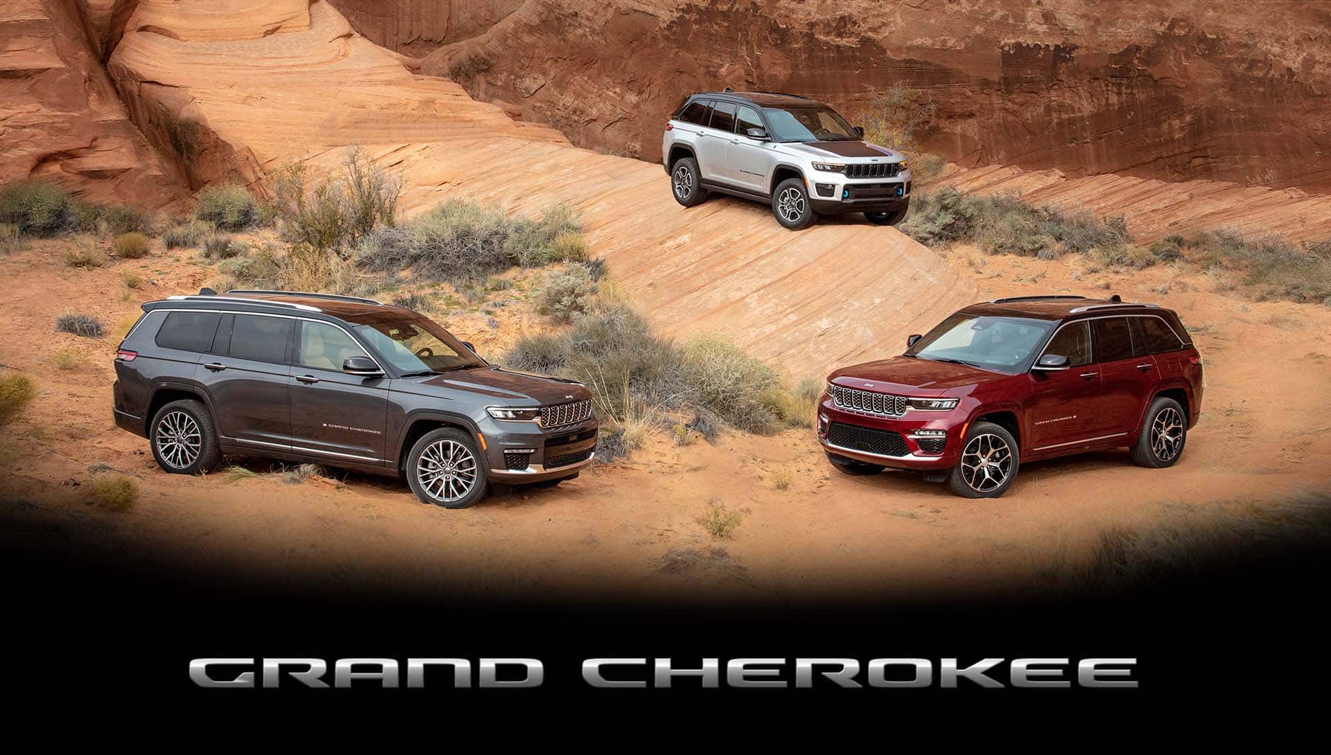A 2022 Jeep Grand Cherokee Summit Reserve, a 2022 Jeep Grand Cherokee L Summit Reserve and a 2022 Jeep Grand Cherokee Trailhawk 4xe parked off-road on a rocky slope.