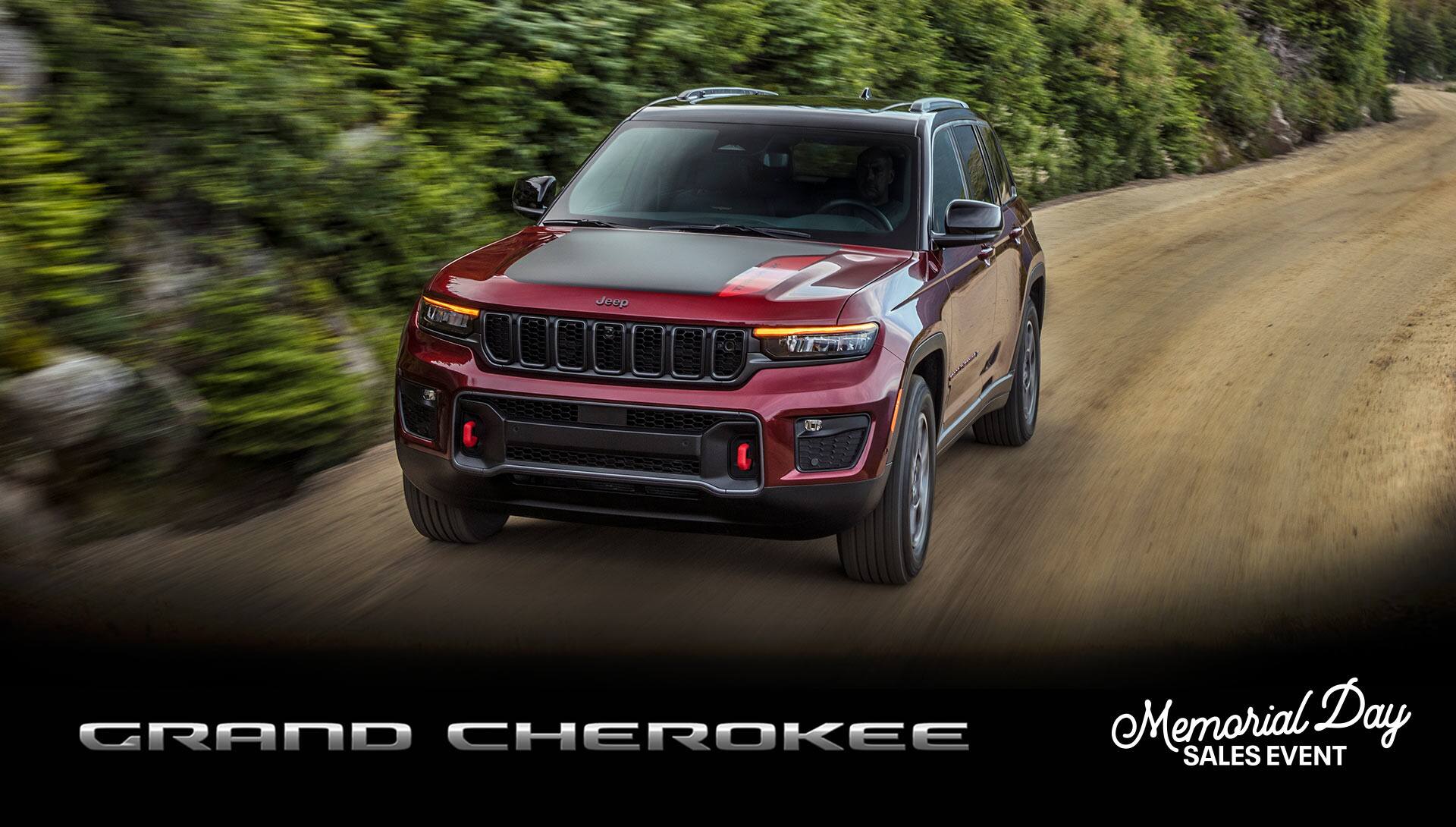 El Jeep Grand Cherokee Trailhawk 2022​​​​​​​ circulando por un camino de tierra con el fondo desenfocado para denotar su velocidad.
