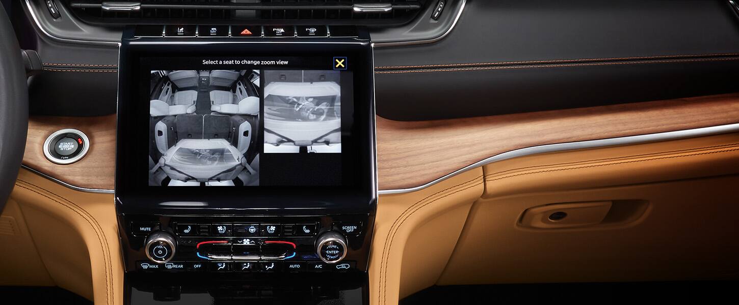 The Uconnect touchscreen inside the 2022 Jeep Grand Cherokee displaying three different angles from the rear seat camera.