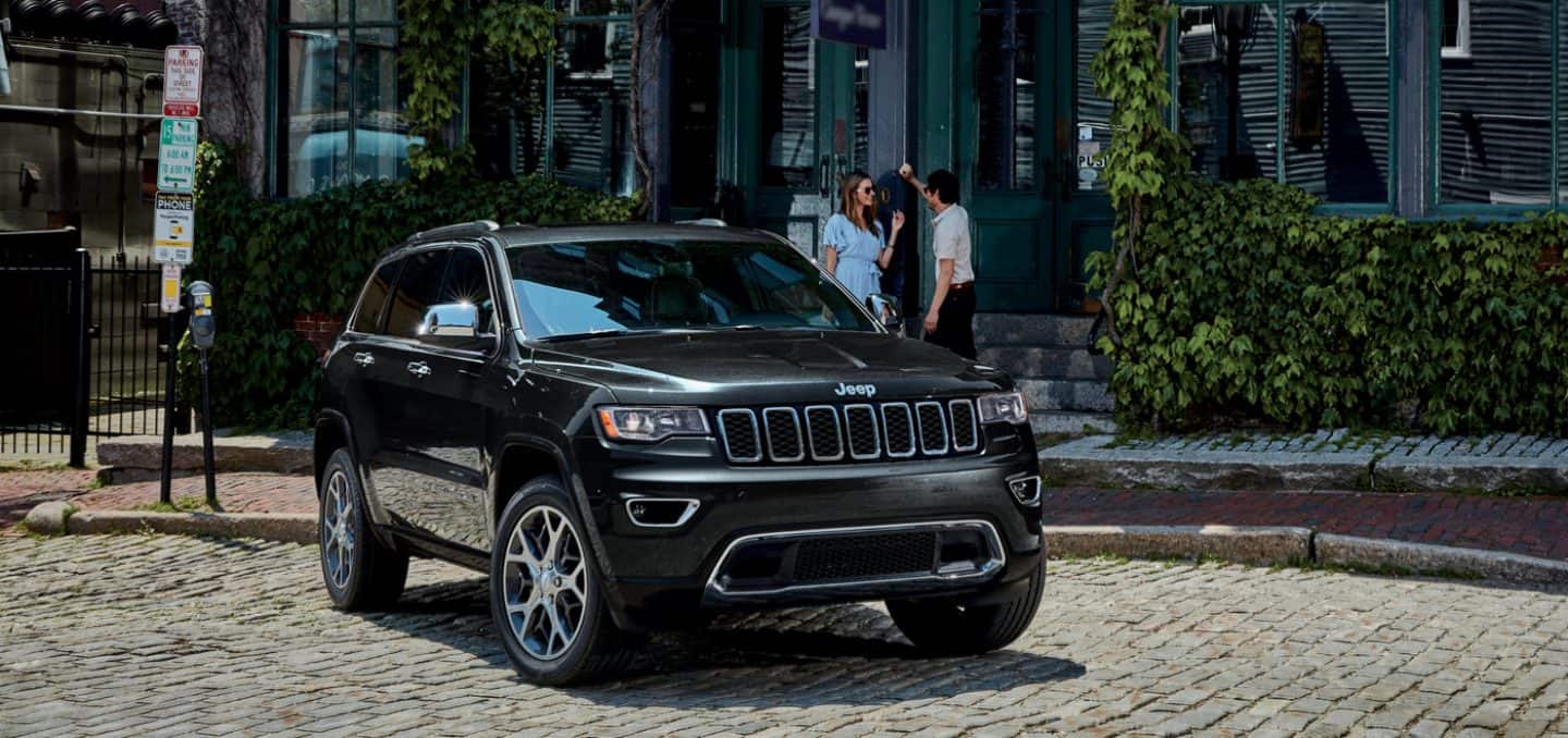 Display The 2022 Jeep Grand Cherokee WK Limited parked on a cobblestone street.