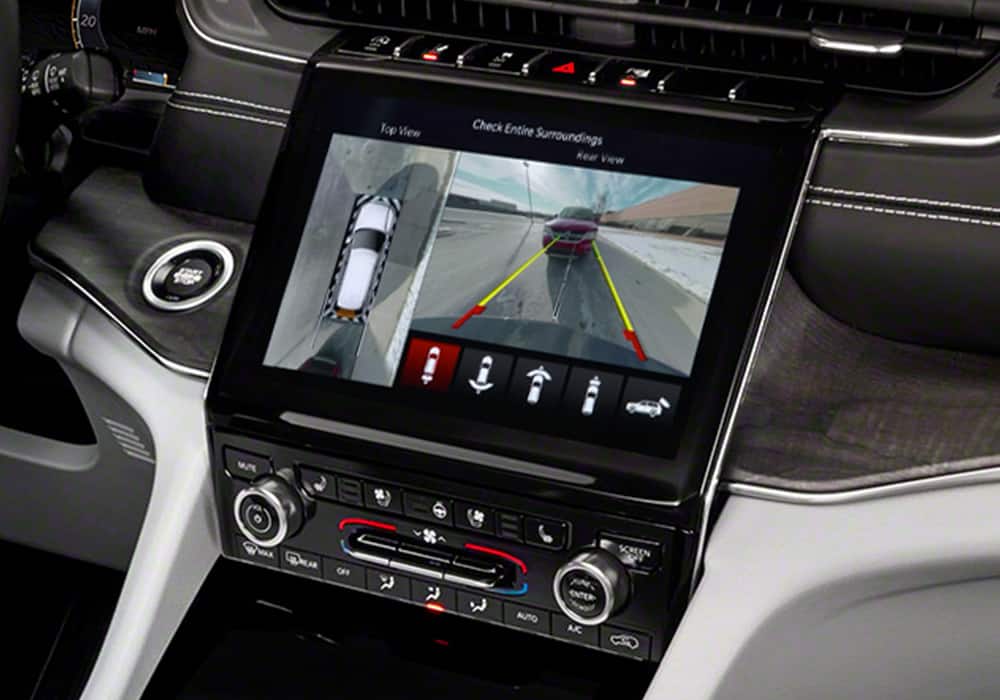 The touchscreen in the 2022 Grand Cherokee displaying a split screen of the top view and rear view surround view camera angles.