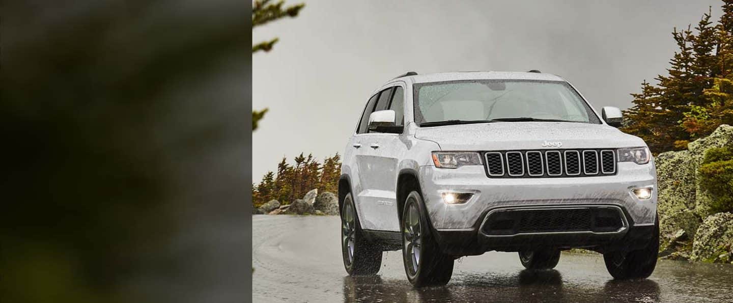 The 2022 Jeep Grand Cherokee WK Limited being driven on a rain-slicked road.