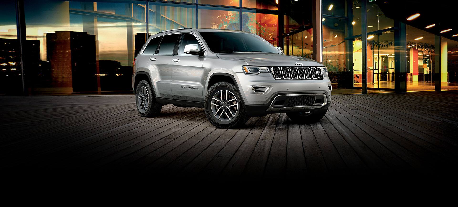 The 2022 Jeep Grand Cherokee WK Limited parked on a boardwalk outside a well-lit, glassed-in building.