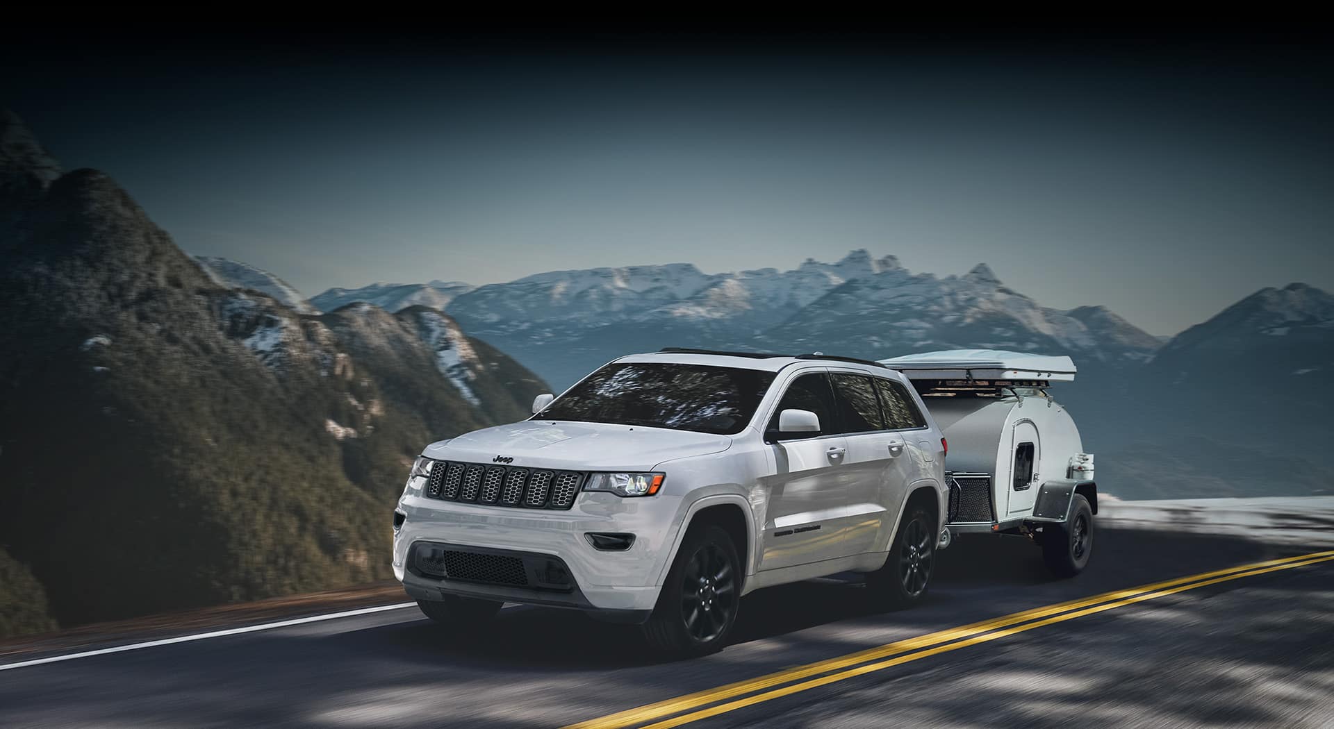 The 2022 Jeep Grand Cherokee WK Laredo X with the Altitude Appearance Package towing a small trailer.