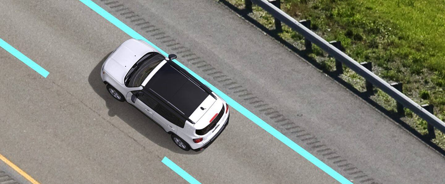 The 2022 Jeep Renegade with illustrated bars overlaid on the lane markings on either side, with a dashed bar to its left and a solid bar to its right indicating the road edge.