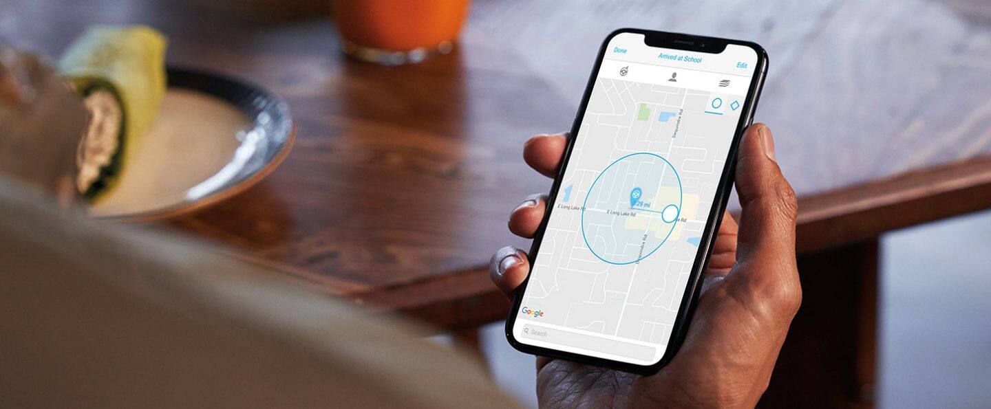 A close-up of a smartphone displaying a street map. The location of a 2022 Jeep Renegade with Family Drive Alert is marked on the map. The app header says