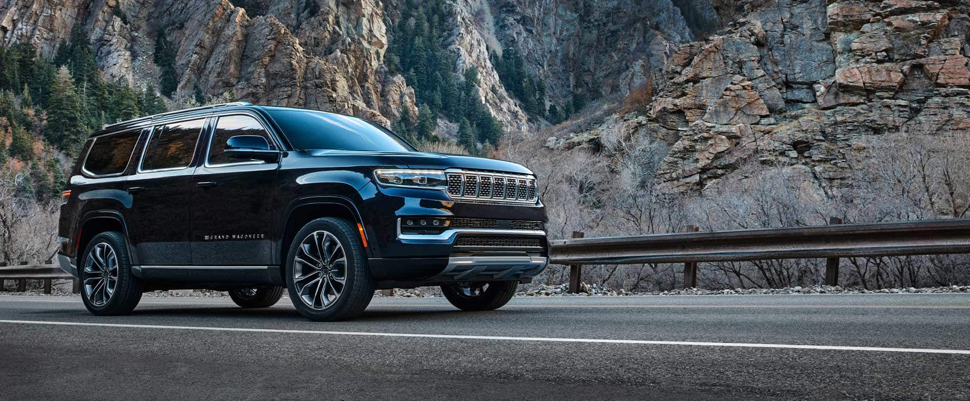 The 2022 Grand Wagoneer parked on the shoulder of a mountain road.