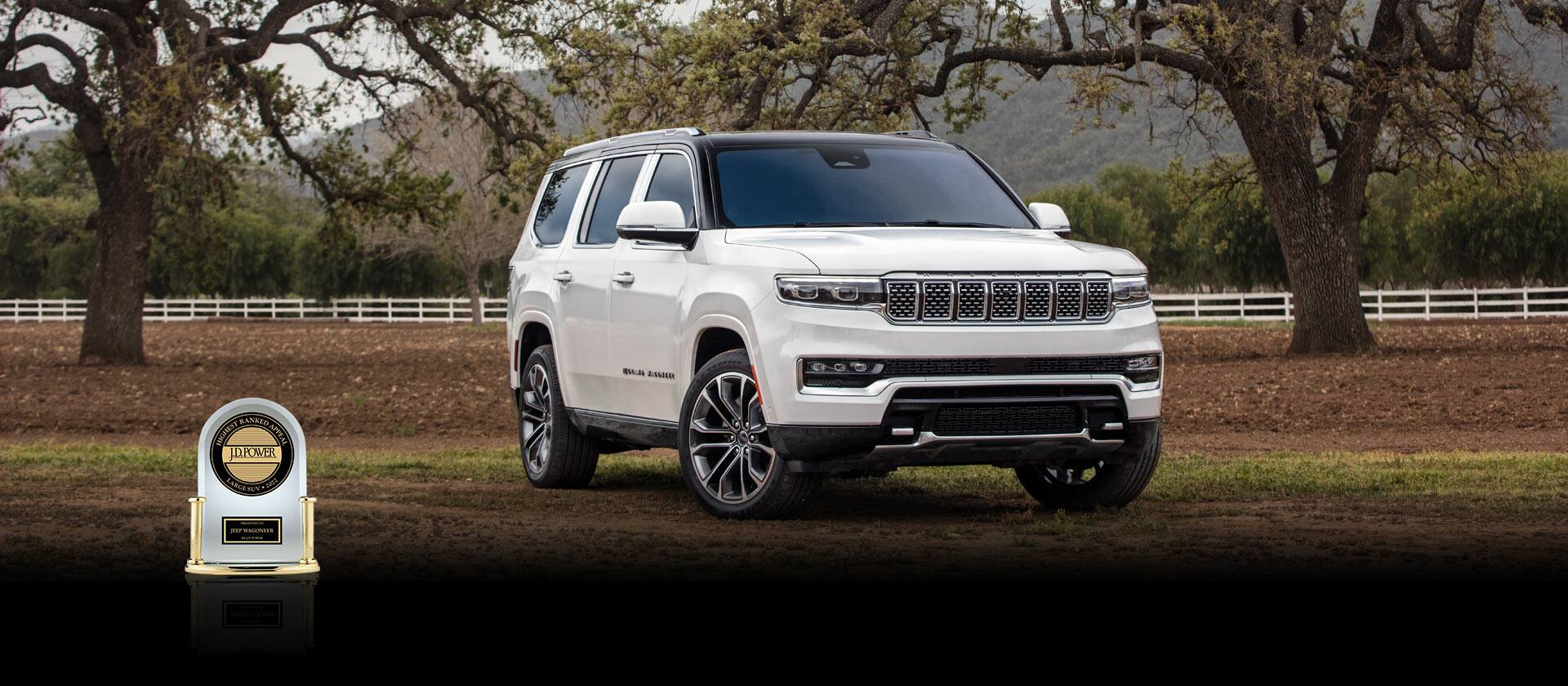 A white 2022 Grand Wagoneer parked near a fenced orchard. In the foreground an award: the J.D.Power Highest Ranked Appeal—Large SUV 2022—presented to Jeep Wagoneer by J.D. Power.