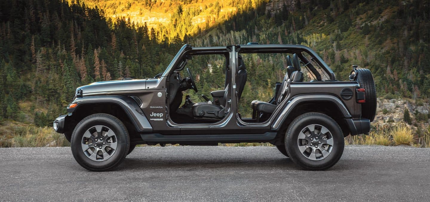 Display A side profile of the 2022 Jeep Wrangler Sahara with its top and doors off.