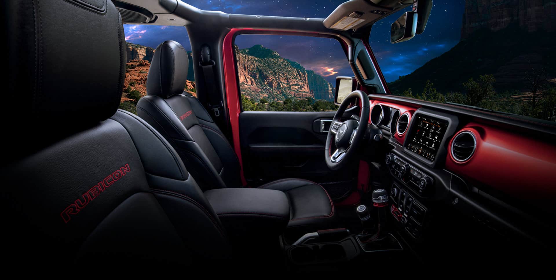 El interior del Jeep Wrangler Rubicon 2022, con enfoque en la fila de adelante, el volante y el tablero.