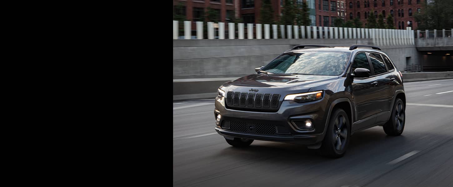 Un Jeep Cherokee Altitude LUX 2023 circulando por una autopista.