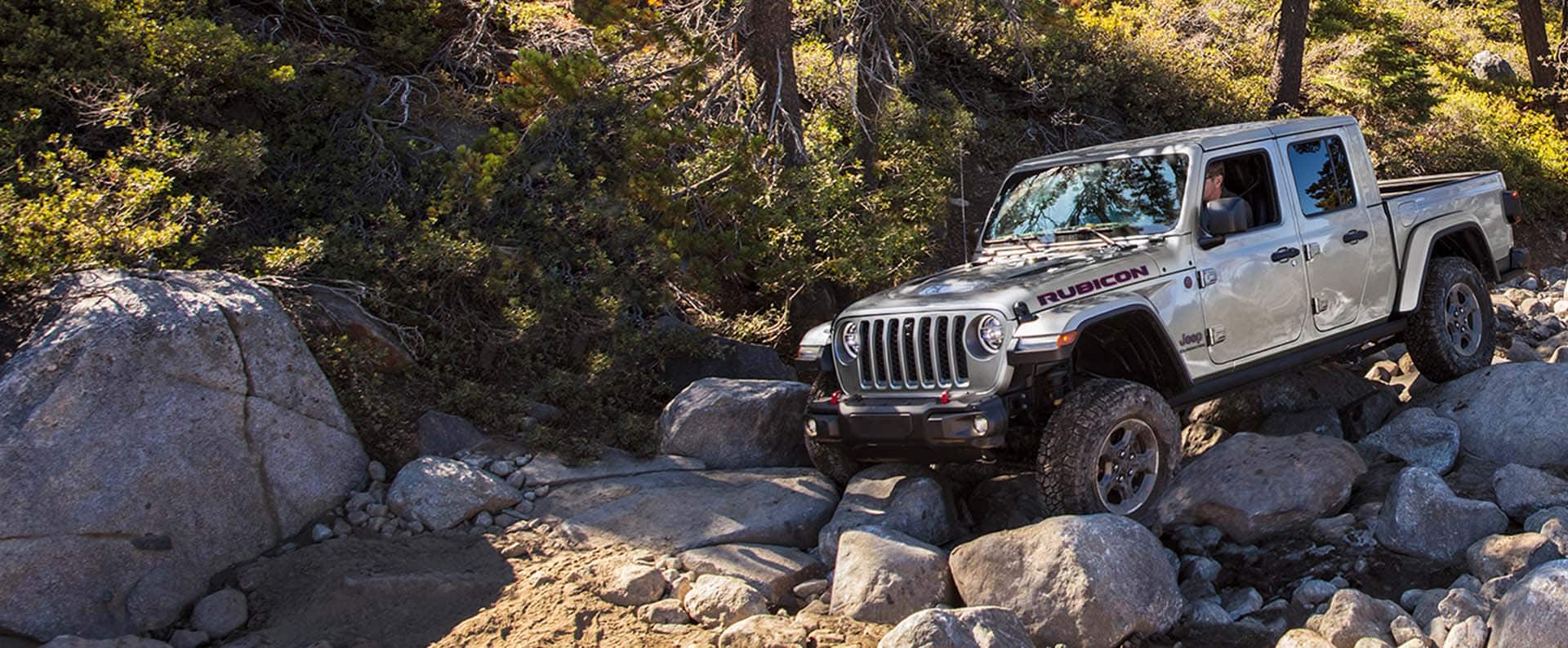 The 2023 Jeep Gladiator Rubicon being driven downhill on a rocky, uneven slope.
