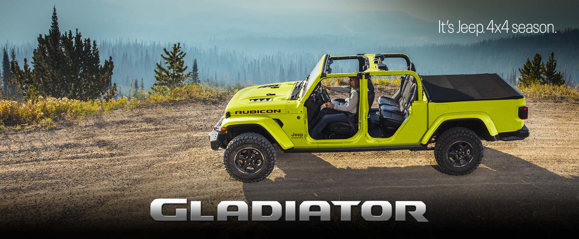 A driver-side profile of a lime green Jeep Gladiator Rubicon parked on a clearing with forest mountain in the background. Gladiator. The It's Jeep Season logo.