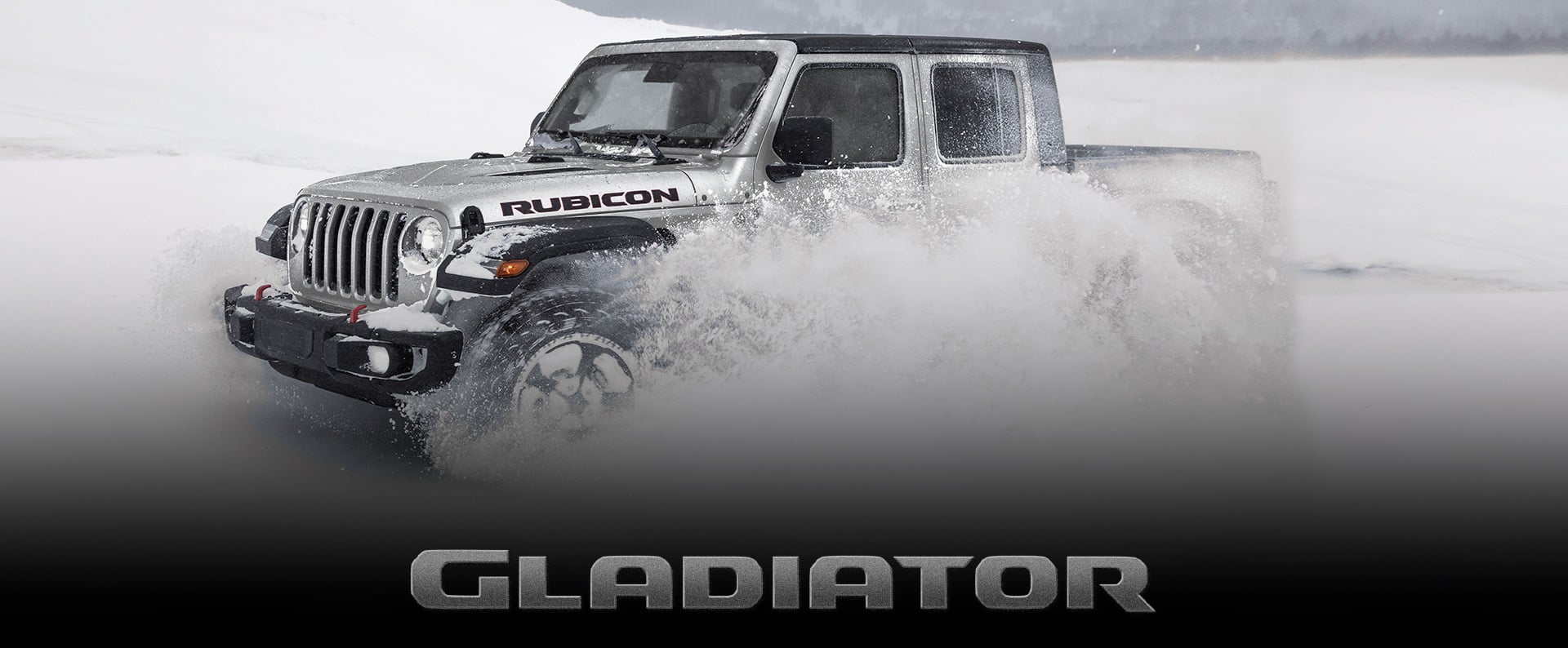 A profile of a 2023 Jeep Gladiator Rubicon being driven through snow, with white powder billowing from the front tires. Gladiator.