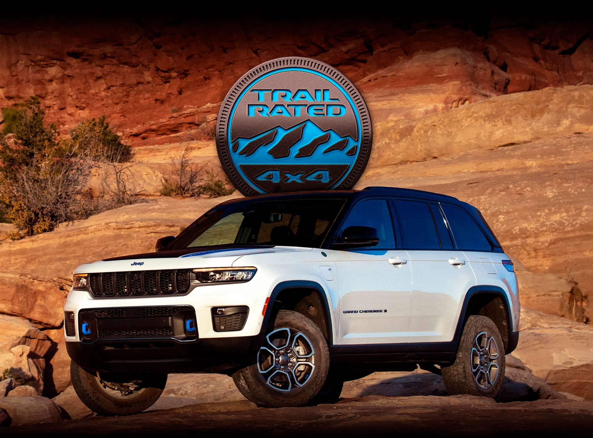 The 2023 Jeep Grand Cherokee 4xe parked on bare rock with a cliff face rising behind it.