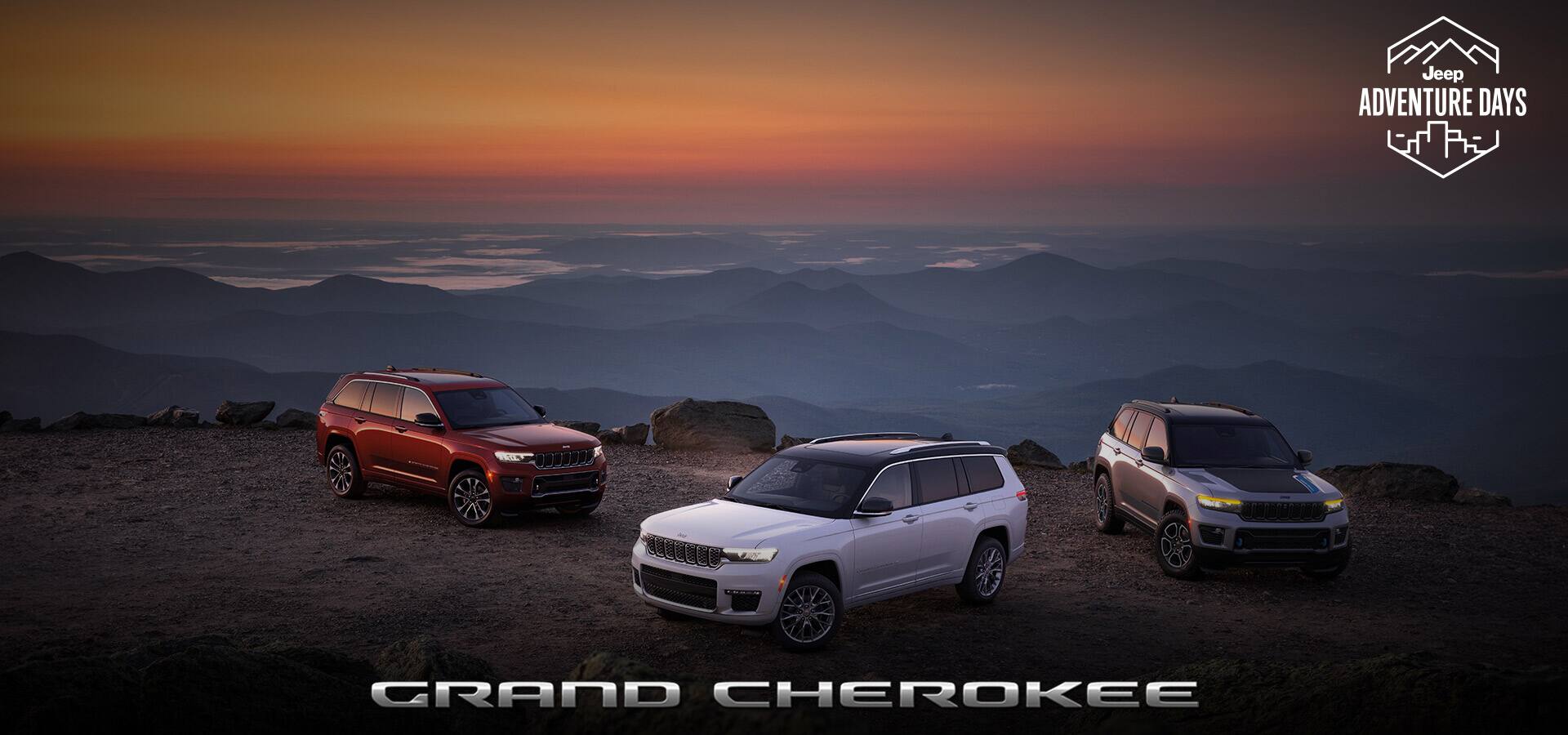Three Jeep Grand Cherokee models parked off-road on a hilltop at twilight: from left to right, a red 2023 Jeep Grand Cherokee L Overland, a white 2023 Grand Cherokee L Summit Reserve and a silver 2023 Grand Cherokee Trailhawk 4xe. Jeep Adventure Days logo. Grand Cherokee.