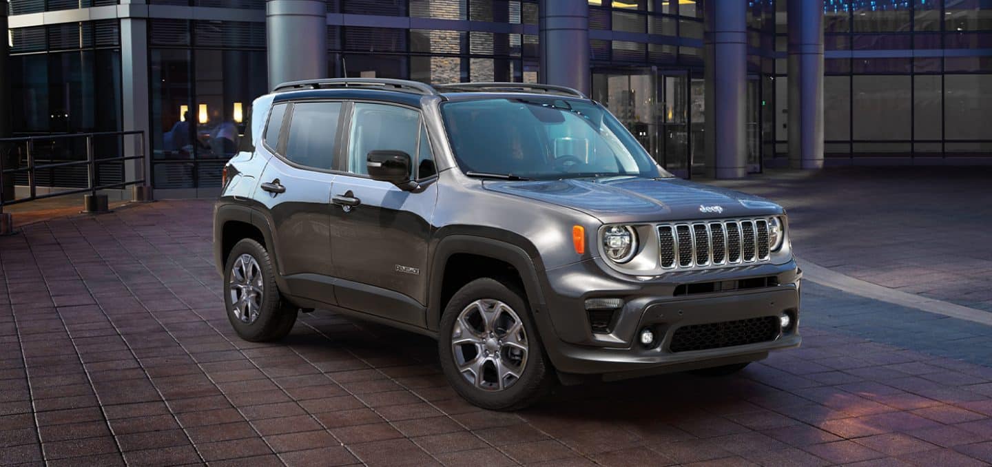 Display A front three-quarter view of a gray 2023 Jeep Renegade Limited parked in the courtyard of a contemporary building.
