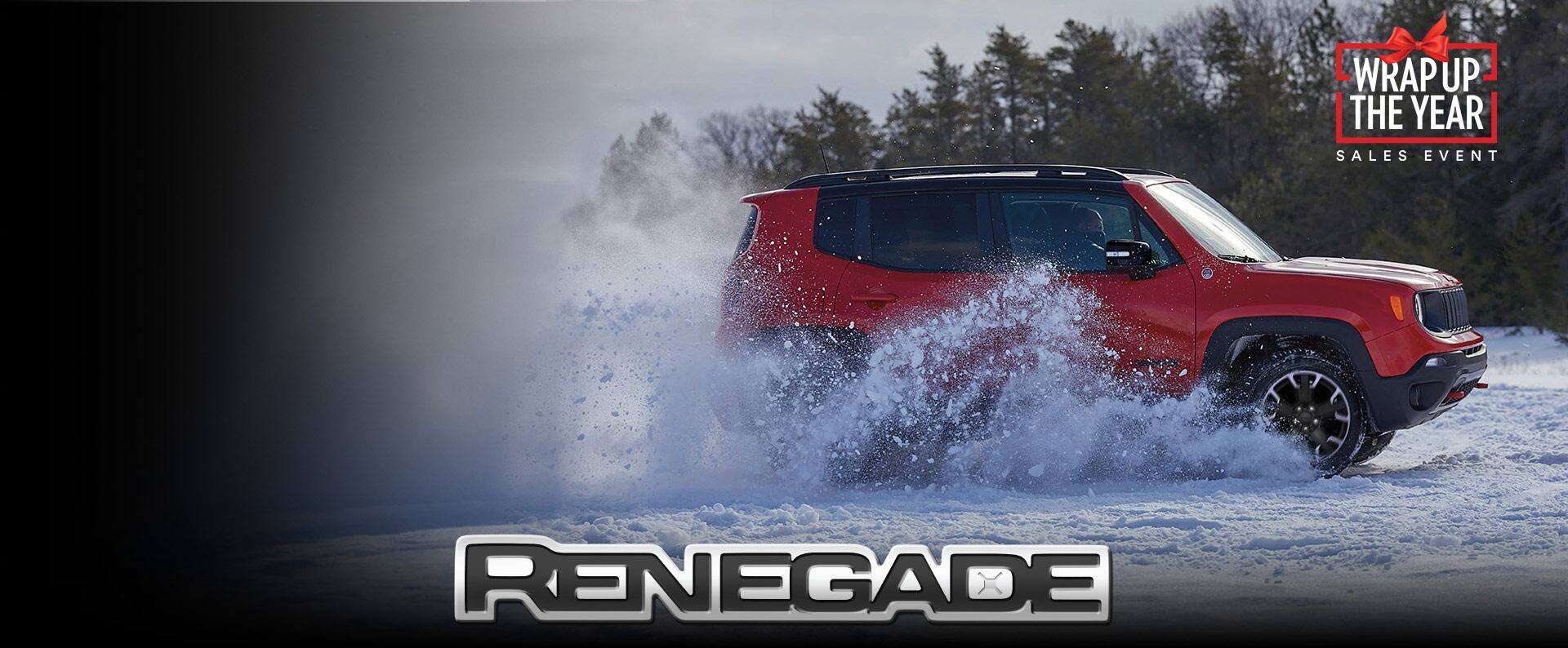A passsenger-side profile of a red 2023 Jeep Renegade Trailhawk being driven through the snow off-road.