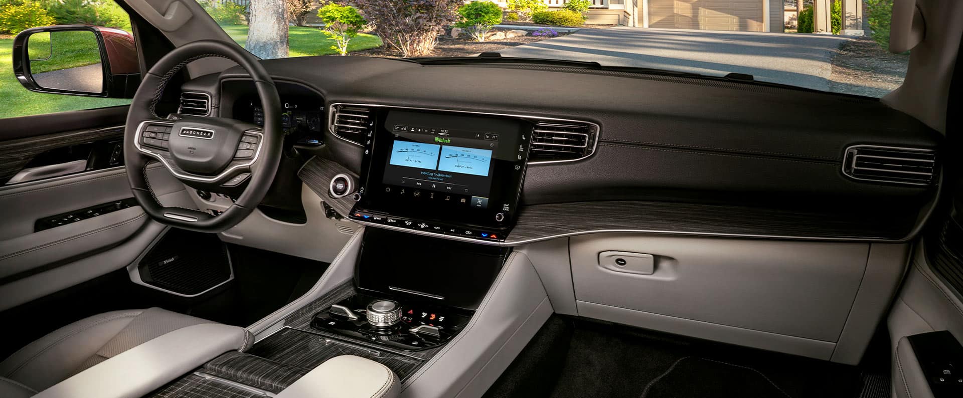 Interior del Wagoneer 2023, con el foco puesto en el volante, la pantalla táctil Uconnect y el tablero.