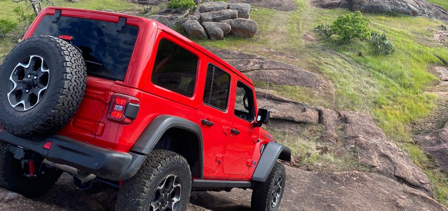 2023 Jeep Wrangler in red driving down the a steep rock face