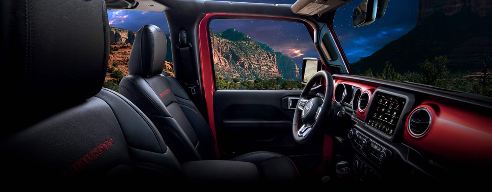 The front row of the 2023 Jeep Wrangler Rubicon with the steering wheel, dashboard and touchscreen included.