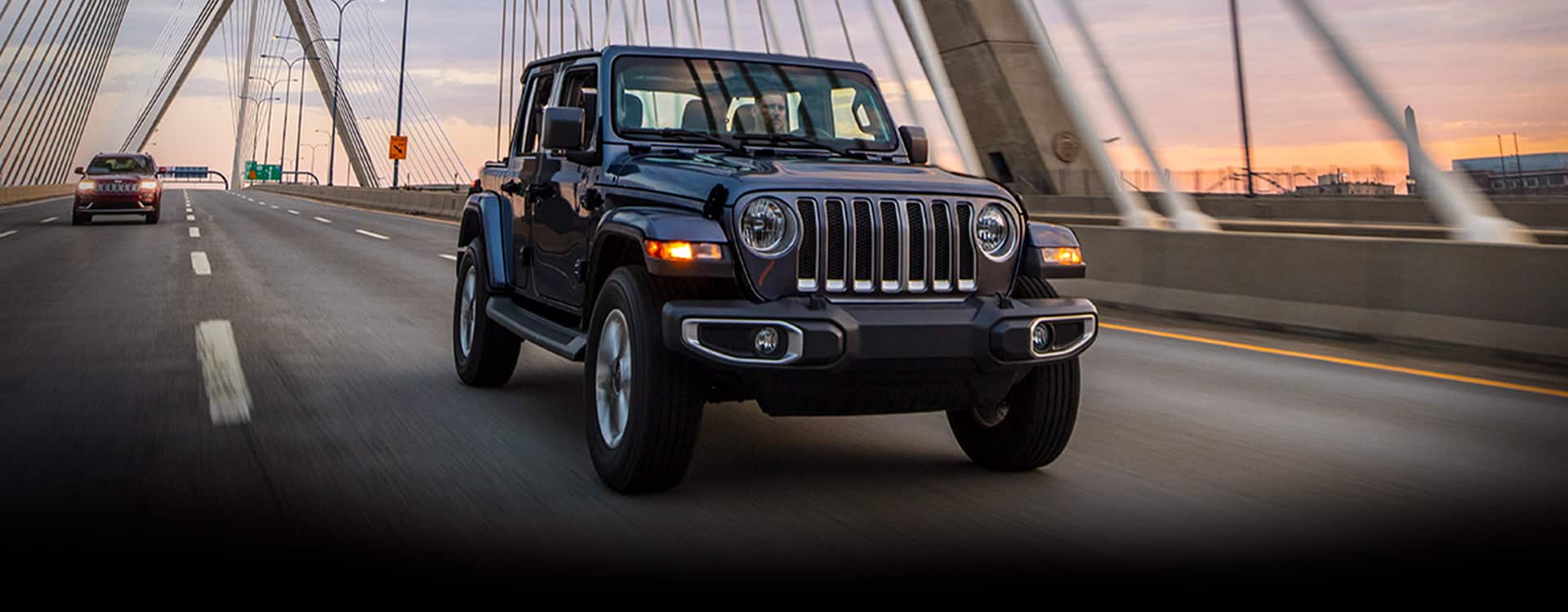 The 2023 Jeep Wrangler Overland being driven over a bridge.