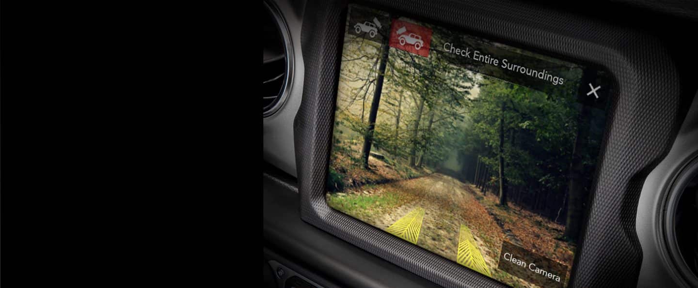 The touchscreen in the 2023 Jeep Wrangler Sahara displaying the view from the forward-facing camera, with projected tire paths shown.