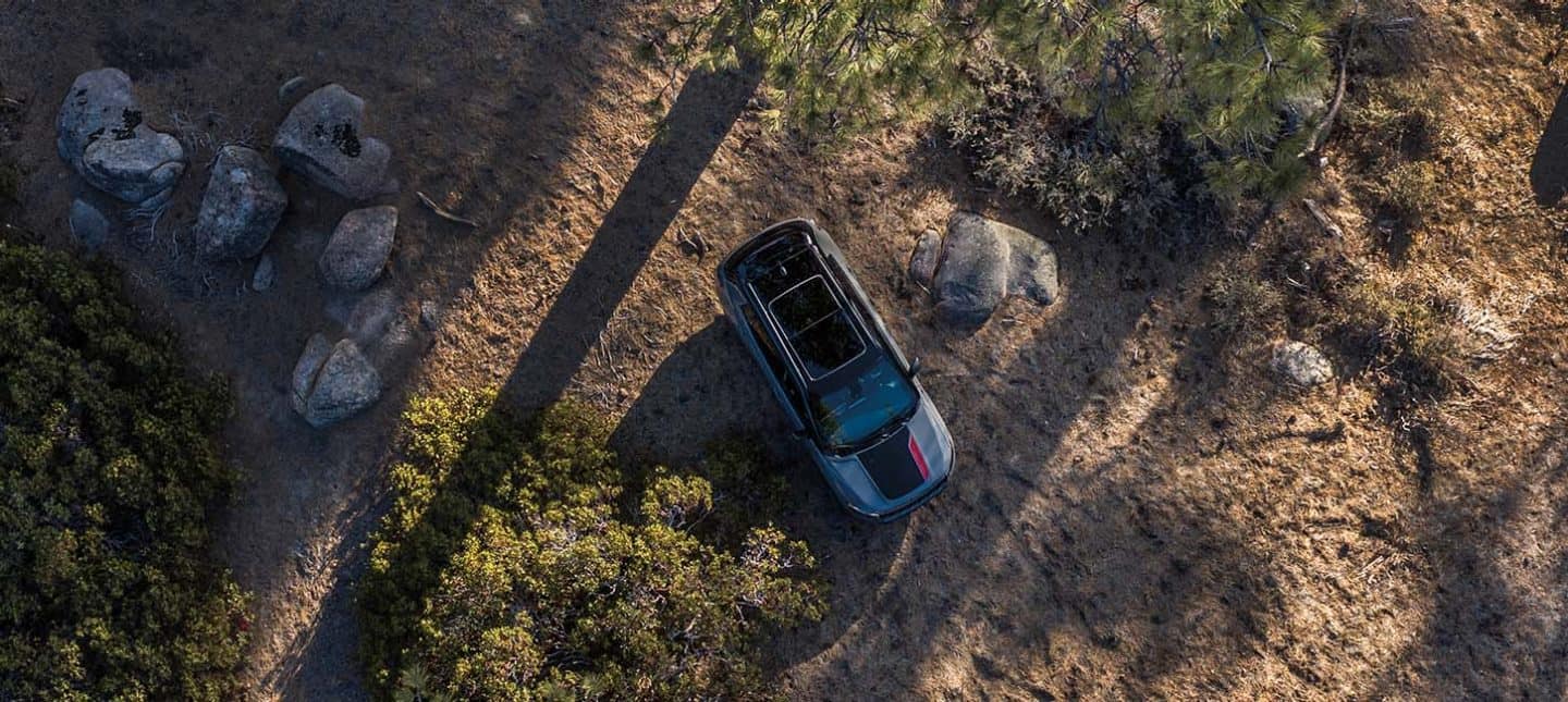 Vista aérea de un Jeep Compass Trailhawk 2024 circulando por un sendero fuera de la carretera.