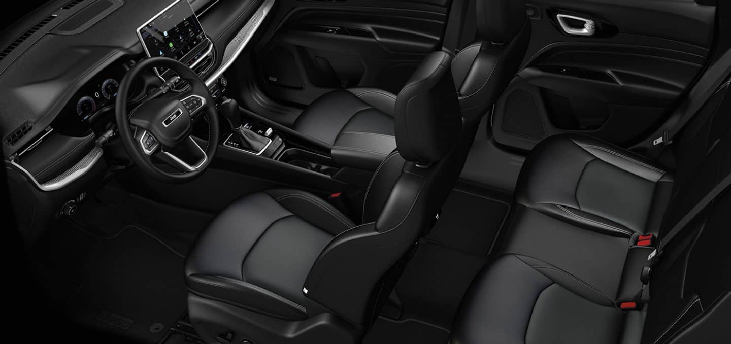 Display An overhead angle of the interior of a 2024 Jeep Compass Limited, focusing on the front and rear seats.