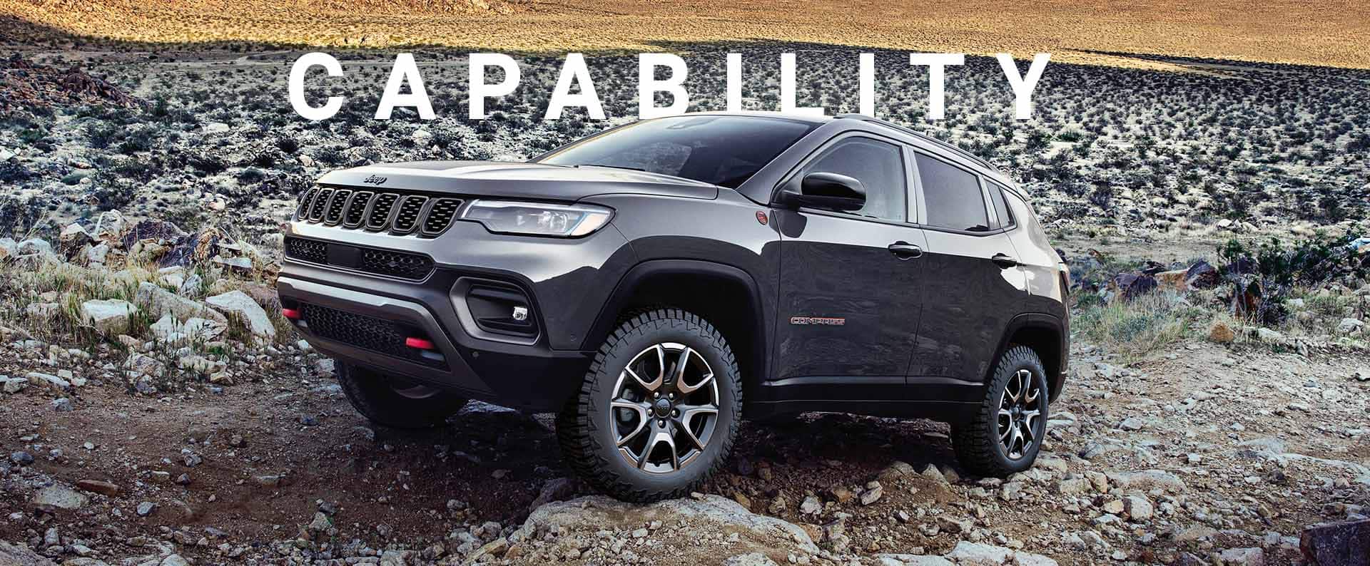 Un Jeep Compass Trailhawk 2024 atravesando rocas y piedras grandes y pequeñas en un camino fuera de la carretera. Capacidad.